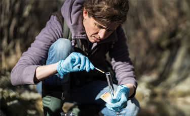 researcher with blue gloves taking samples