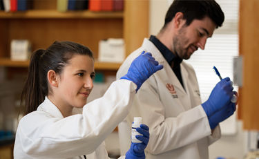 researchers with blue gloves measuring dosage